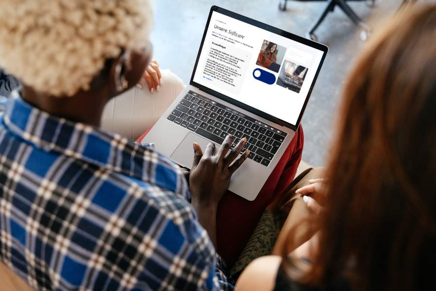 AccessiWay - Digitale Barrierefreiheit Zwei Frauen schauen auf einen Laptopbildschirm.